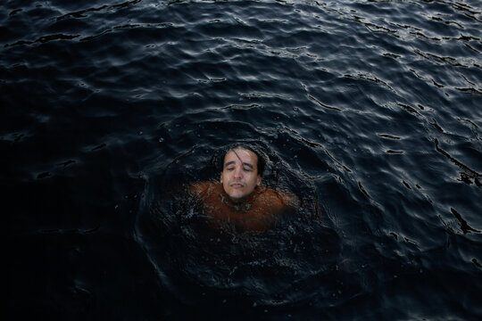 High angle view of shirtless man swimming in lake