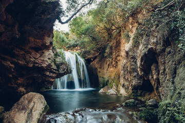 Scenic view of waterfall over rock formations at forest