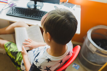 High angle view of boy studying while sitting on chair at home