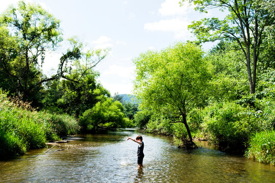 High angle view of boy playing with water in lake by trees