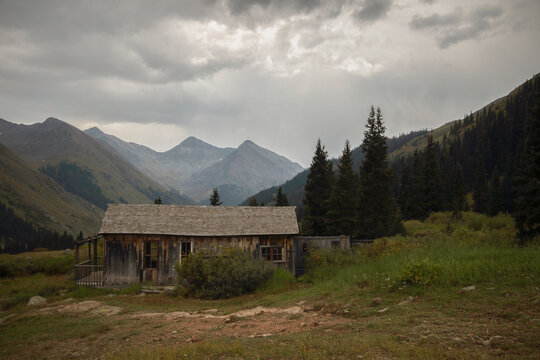 Log cabin at Ghost Town against mountains and cloudy sky