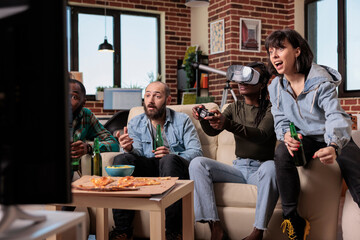 Fototapeta na wymiar Men and women using vr glasses to play video games at fun home gathering, playing competition on television. Enjoying leisure activity with beer bottles and snacks, 3d gaming.