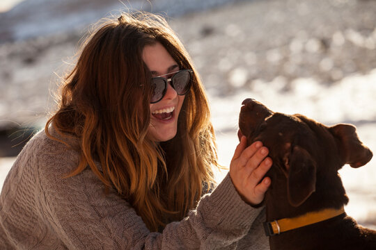 Happy woman petting dog during winter
