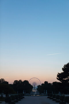 Ferris Wheel against sky at amusement park during sunset