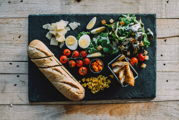 Overhead view of food on slate over wooden table