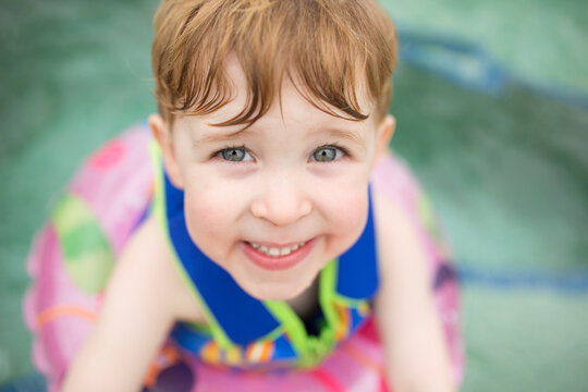 High angle portrait of smiling boy with inflatable ring floating on swimming pool