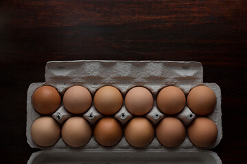 Overhead view of brown eggs in carton on table