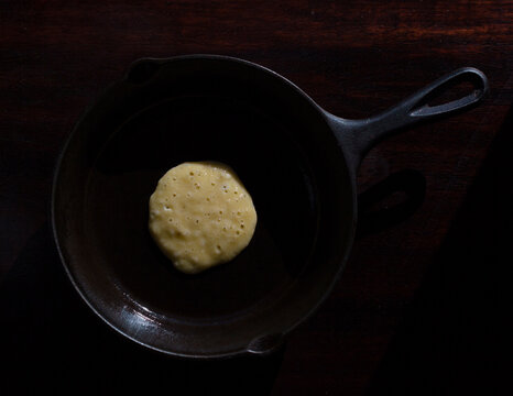 Overhead view of pancake batter in frying pan on table