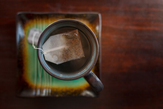 Overhead view of teabag in cup on table