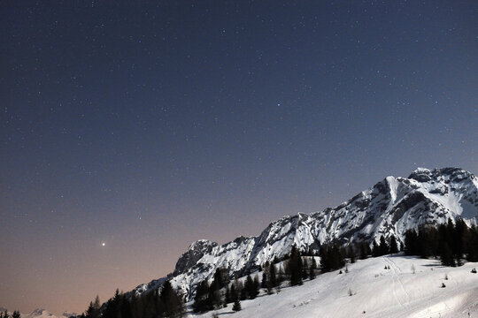 Low angle view of snowcapped mountain against sky at night