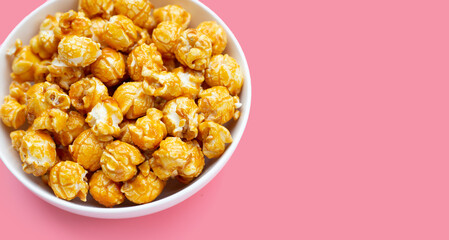 Honey caramel popcorn on pink background.