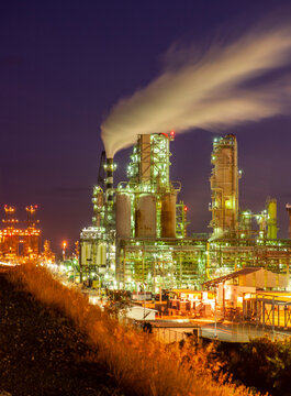 Illuminated petrochemical plant against sky