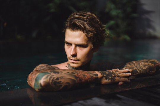 Close-up of thoughtful tattooed man in swimming pool
