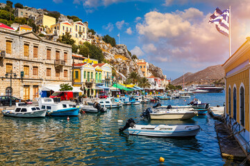Fototapeta premium View of the beautiful greek island of Symi (Simi) with colourful houses and small boats. Greece, Symi island, view of the town of Symi (near Rhodes), Dodecanese.