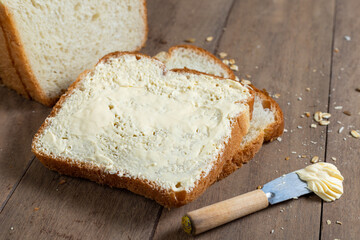 Loaf Bread Slices with margarine on a Wooden Desk