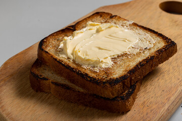 Toasted Loaf Bread with Margarine on a wood over the table