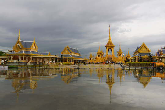 Royal crematorium reflecting on water against cloudy sky