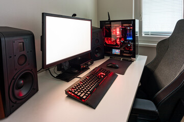 Powerful personal computer gamer rig with white screen. Professsional gaming empty room studio with neon lights and RGB powerful computer, keyboard and mouse. White screen on pc display.