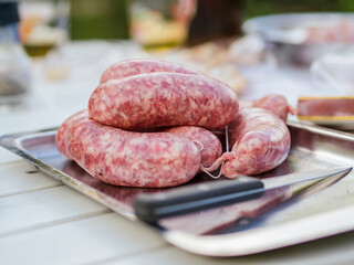 Close-up of sausages with knife in plate on wooden table at yard