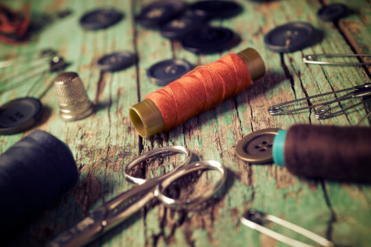 High angle close-up of various sewing items on old wooden table