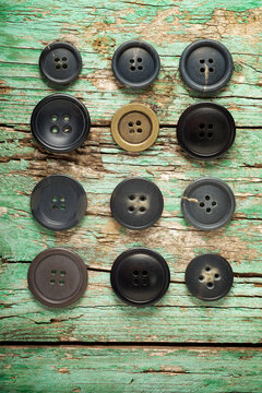 Overhead view of buttons arranged on old wooden table