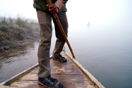 Low section of man rowing boat on lake during foggy weather