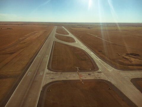 Aerial view of airport runway against sky during sunny day