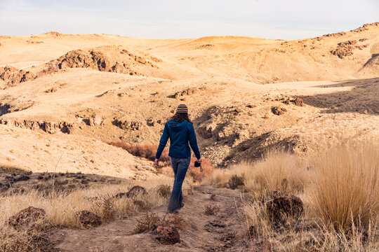 Woman hiking on dirt path in dry landscape