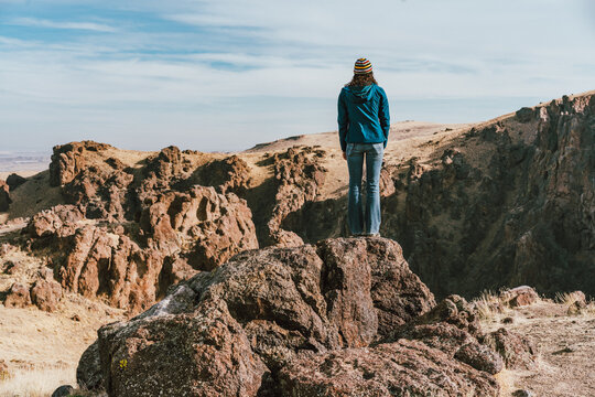 Woman standing on rock overlooking a canyon