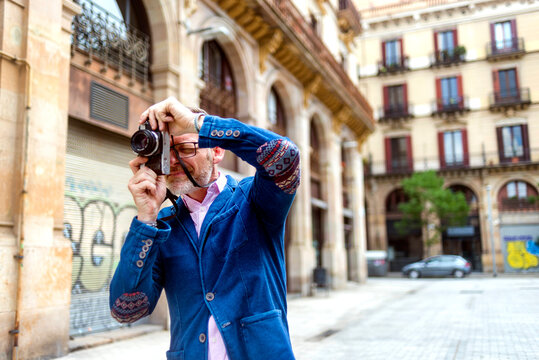 Stylish photographer man taking photo in the street