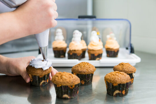 Chef topping cupcakes with homemade butter cream