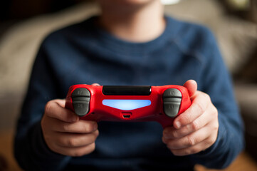 Young boy playing with video game controller while playing video game