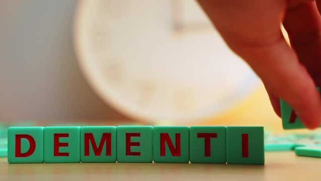 The word DEMENTIA made of small colorful cubes and many scrambled letters on the table. The loss of cognitive functioning thinking, remembering, and reasoning . High quality 4k footage