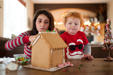Brother and Sister decorate a xmas gingerbread house together at home