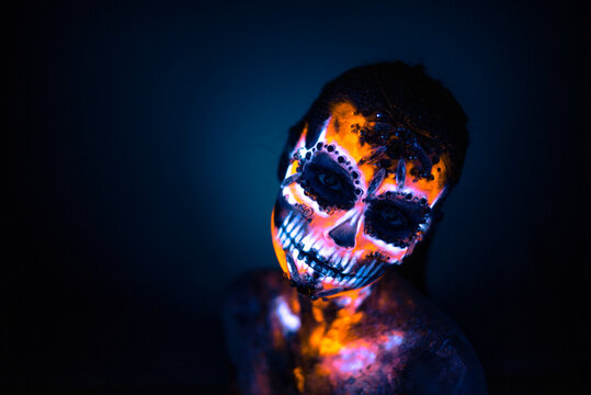 Girl's face painted UV skull
