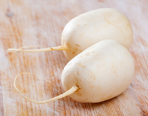 Image of fresh white turnip on wooden table in home kitchen