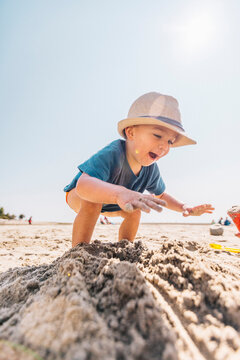 Low angle of toddler boy playing on a sandy beach