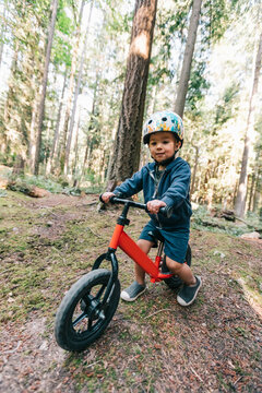 Toddler boy biking in the forest