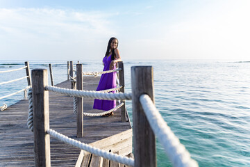 Black woman leaning on the ropes at a pier while smiling