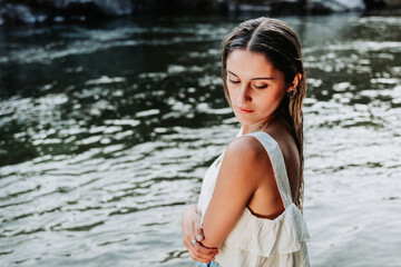 Fototapeta premium Beautiful blonde girl, using a white t-shirt in a natural space, by the river.
