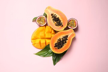 Fresh ripe papaya and other fruits on pink background, flat lay