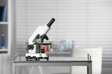 Modern medical microscope on metal table in laboratory, space for text
