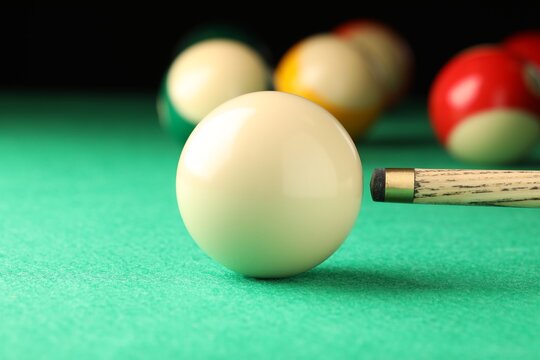 Classic plain billiard ball and cue on green table
