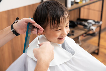 ヘアーカットする笑顔の男の子