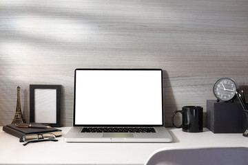 Laptop computer, alarm clock, coffee cup, picture frame and glasses. Empty screen for your advertise text.