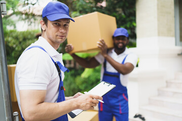 Portrait of courier black man in the truck thumb up and smiling to camera while sitting in driver seat, Optimistic man worker with delivery occupation.