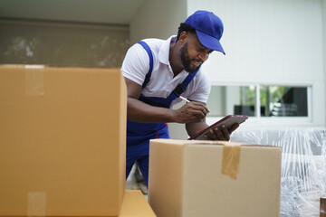 Portrait of courier black man in the truck thumb up and smiling to camera while sitting in driver seat, Optimistic man worker with delivery occupation.