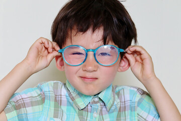 Toddler boy with blue light blocking glasses - obrazy, fototapety, plakaty