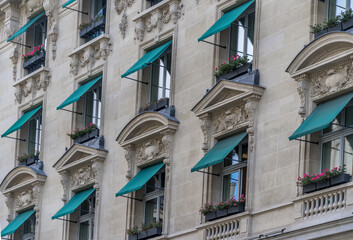 Fototapeta na wymiar Classic Parisian windows with classist décor and green awning
