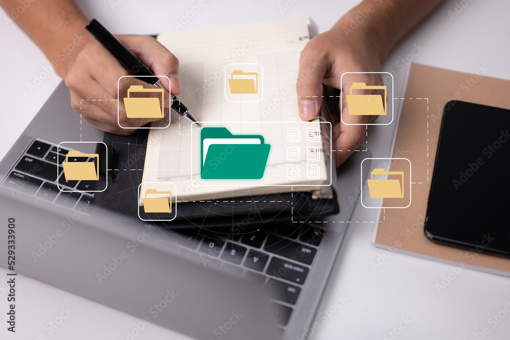 Aufkleber Paperless office concept based on e-documents. A businessman types on a laptop keyboard while viewing electronic document icons on a virtual screen.